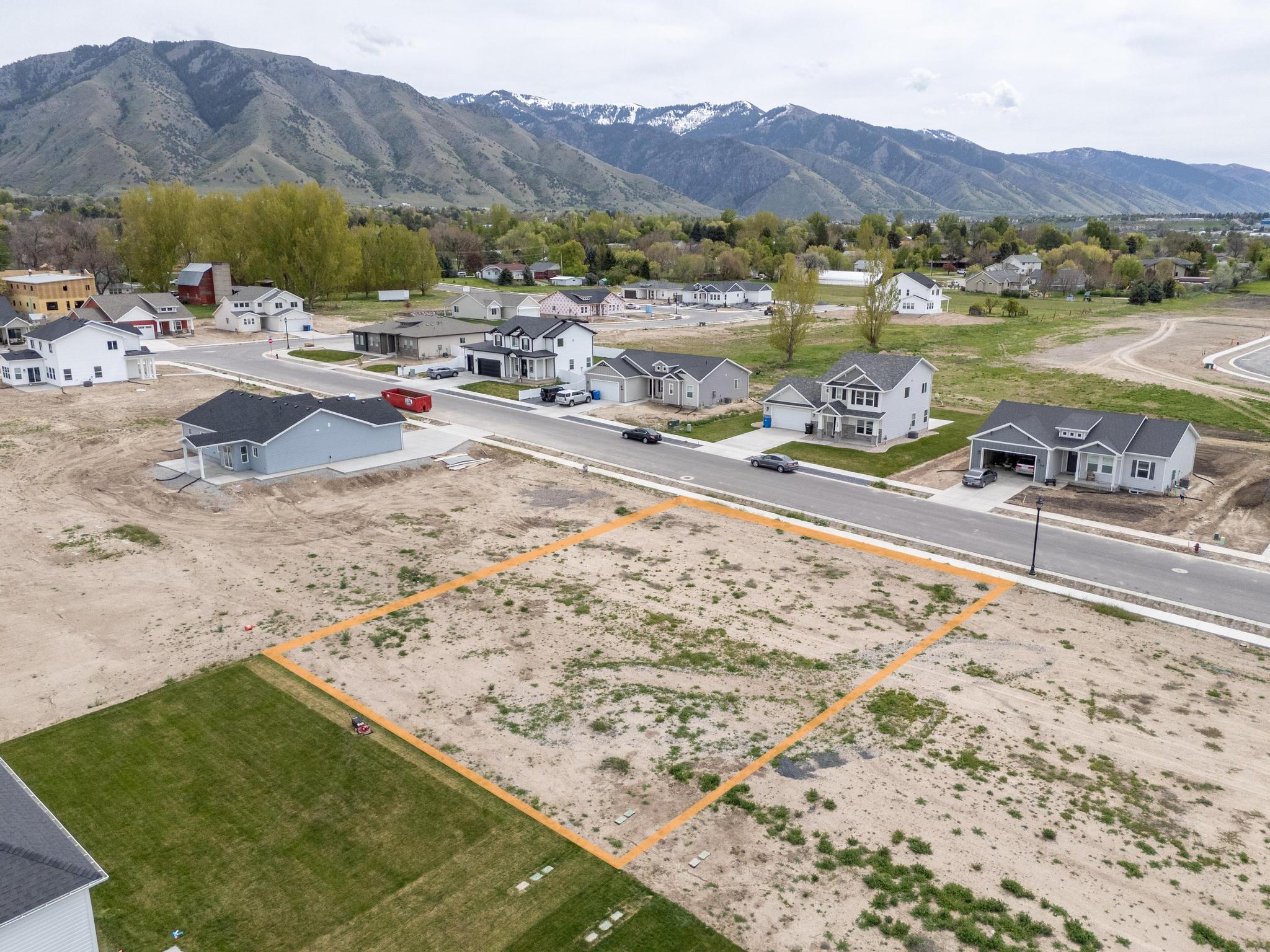 Aerial view of residential area with property boundaries highlighted and mountains