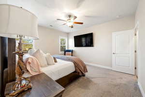Carpeted bedroom with baseboards and ceiling fan