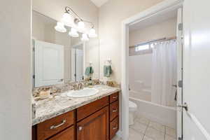 Full bathroom featuring vanity, shower / tub combo with curtain, and light tile patterned flooring