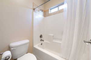 Bathroom featuring toilet and shower / bath combo