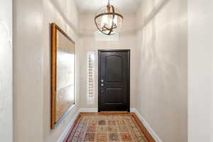 Foyer featuring hanging lights, light wood finished floors, and a textured wall
