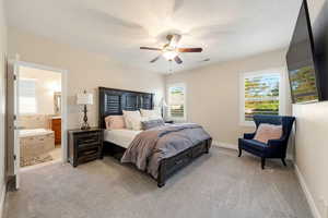 Bedroom with light colored carpet, multiple windows, and ceiling fan
