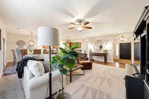 Living area featuring suspended lighting, arched walkways, and a ceiling fan