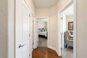 Hall with dark wood-type flooring and dark carpet