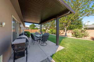 Fenced backyard featuring a patio area, outdoor dining area, and grilling area