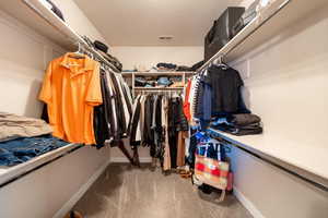 Walk in closet with light colored carpet