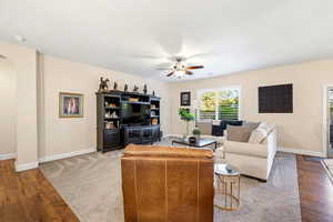 Living room featuring hardwood / wood-style flooring, ceiling fan, and arched walkways