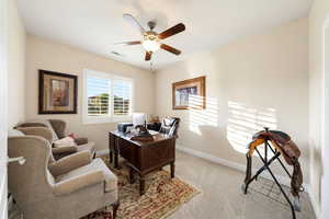 Office space featuring light colored carpet and a ceiling fan