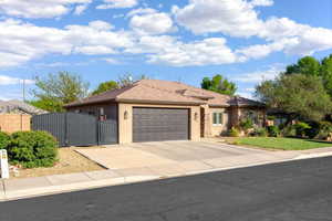 Single story home with a gate, a garage, stucco siding, and driveway