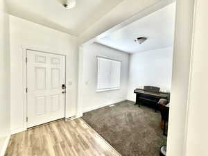 Entryway featuring light wood finished floors and light carpet