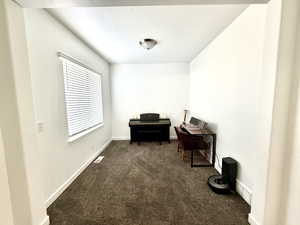Office space featuring dark carpet and baseboards