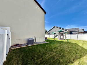 Fenced backyard featuring a playground