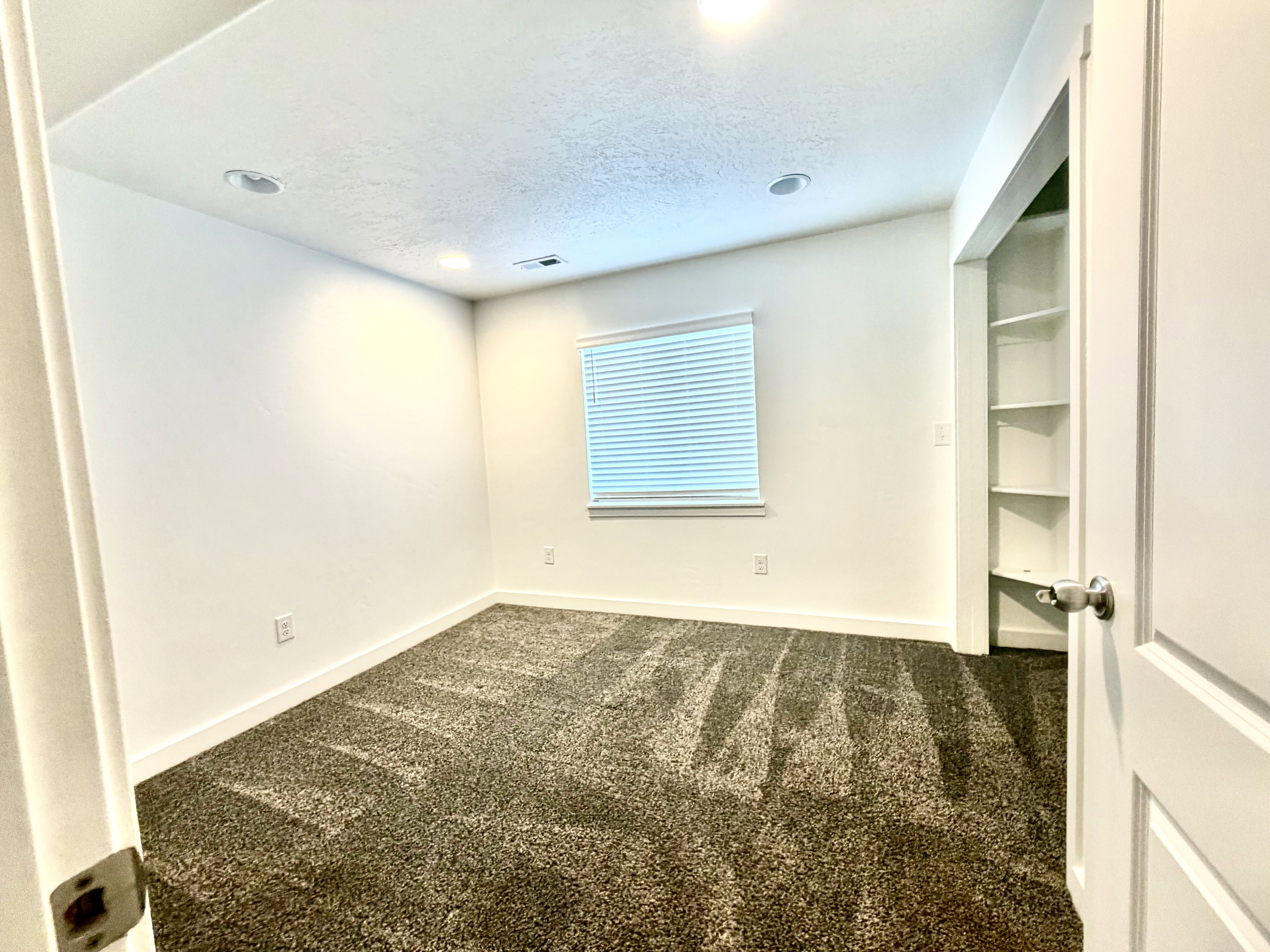 Unfurnished room with dark carpet, a textured ceiling, and recessed lighting