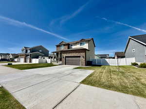 View of front of home with driveway, a residential view, stone siding, and an attached garage