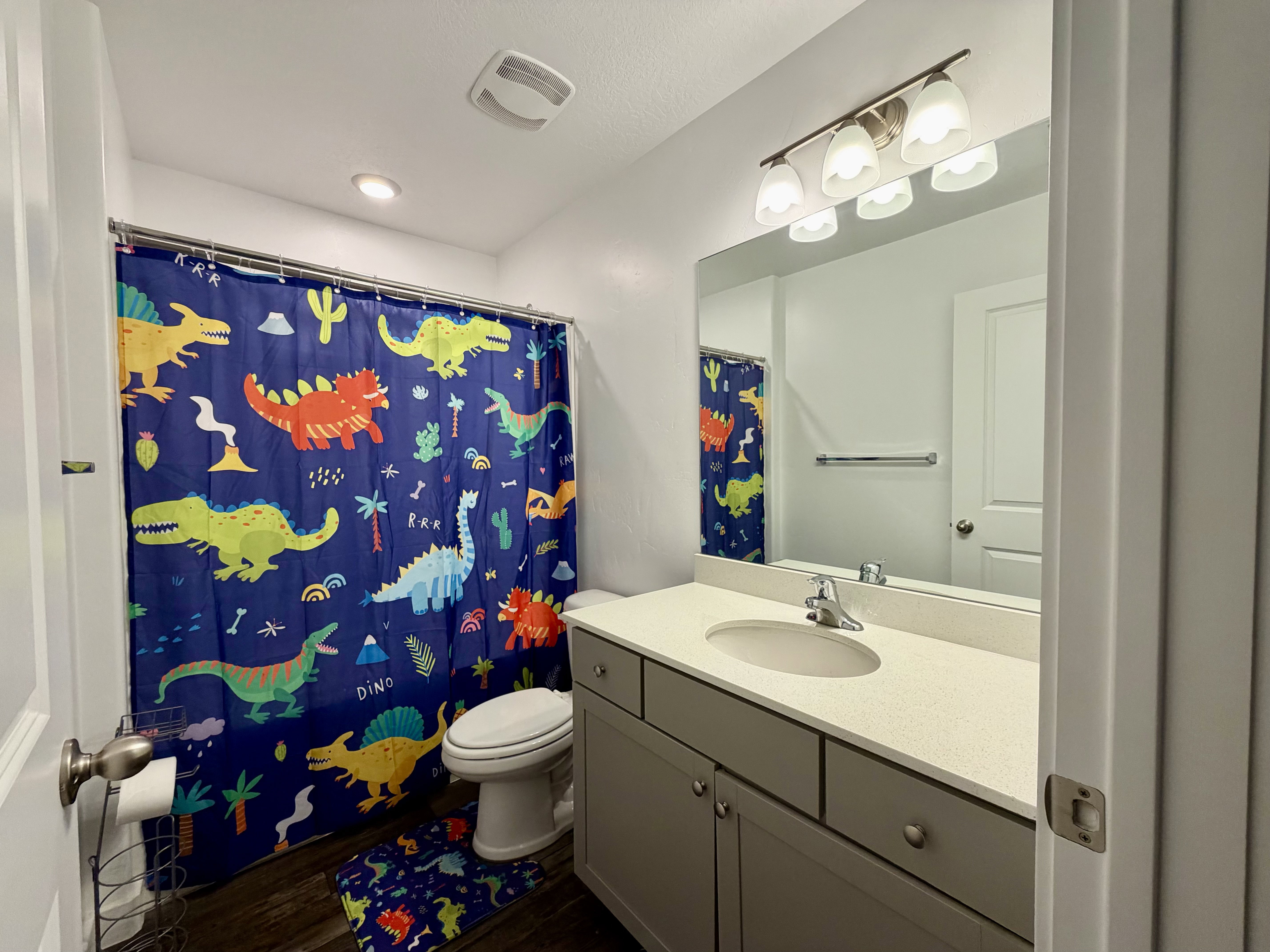 Full bath with vanity, dark wood finished floors, and shower / bathtub combination with curtain