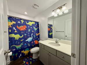 Full bath with vanity, dark wood finished floors, and shower / bathtub combination with curtain