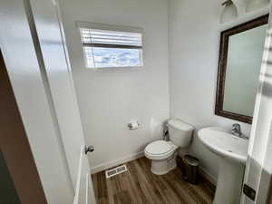 Bathroom with toilet and dark wood-type flooring