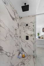 Full bathroom with a textured ceiling and a marble finish shower
