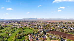 Aerial view of residential area featuring a mountainous background and a local golf course