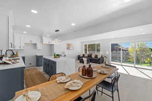Dining room with light wood-style flooring and recessed lighting