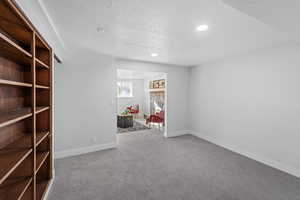 Unfurnished room with light colored carpet, a textured ceiling, and recessed lighting