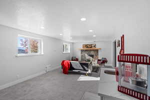 Carpeted bedroom featuring a stone fireplace and a textured ceiling