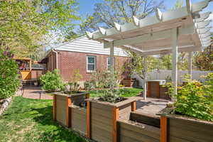 Deck featuring a vegetable garden, a patio area, and a pergola