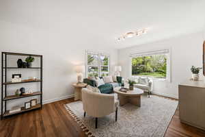 Living room with dark wood-style floors and rail lighting