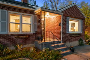 Doorway to property with brick siding and a chimney