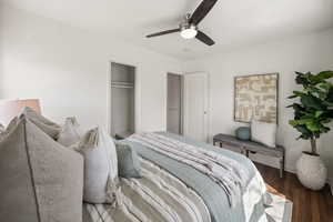 Bedroom featuring wood-type flooring, ceiling fan, and a closet