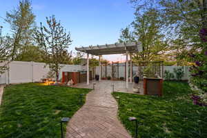 Yard at dusk with a patio, a fenced backyard, and a pergola