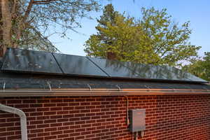 Exterior view of brick siding, a chimney, and a metal roof