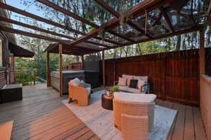 Deck with a hot tub, outdoor seating, and grilling area