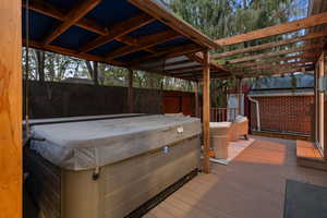 Deck with a fenced backyard and a hot tub