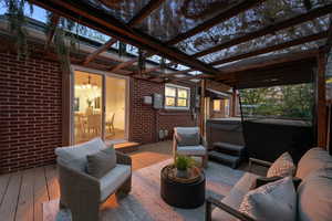 Sunroom / solarium featuring a hot tub, outdoor lounge area, and a deck
