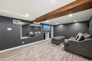 Home theater room featuring beamed ceiling, recessed lighting, and light wood-type flooring