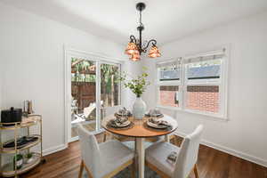 Dining space featuring suspended lighting, dark wood-type flooring, and healthy amount of natural light