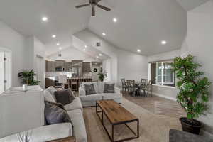 Living room featuring a ceiling fan, light wood finished floors, lofted ceiling, and recessed lighting