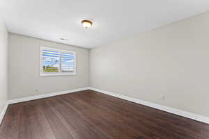 Unfurnished room featuring dark wood-style flooring