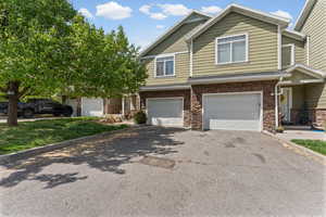 View of front of house featuring driveway, an attached garage, and stone siding