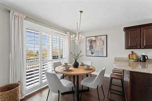 Dining room with hanging lights and dark wood-style floors