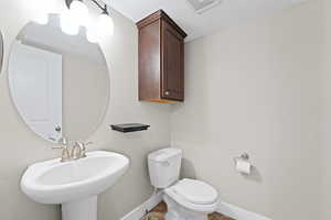 Bathroom with toilet and a textured ceiling