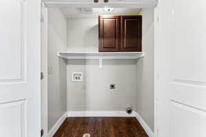 Laundry area with dark wood-type flooring, hookup for an electric dryer, cabinet space, and hookup for a washing machine