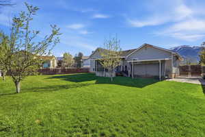 Fenced backyard featuring a deck with mountain view