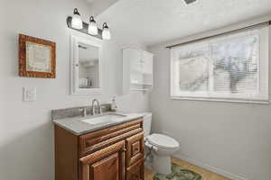 Bathroom with vanity, a textured ceiling, and light tile patterned floors