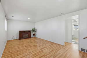 Unfurnished living room featuring light wood-style flooring, a fireplace, and recessed lighting