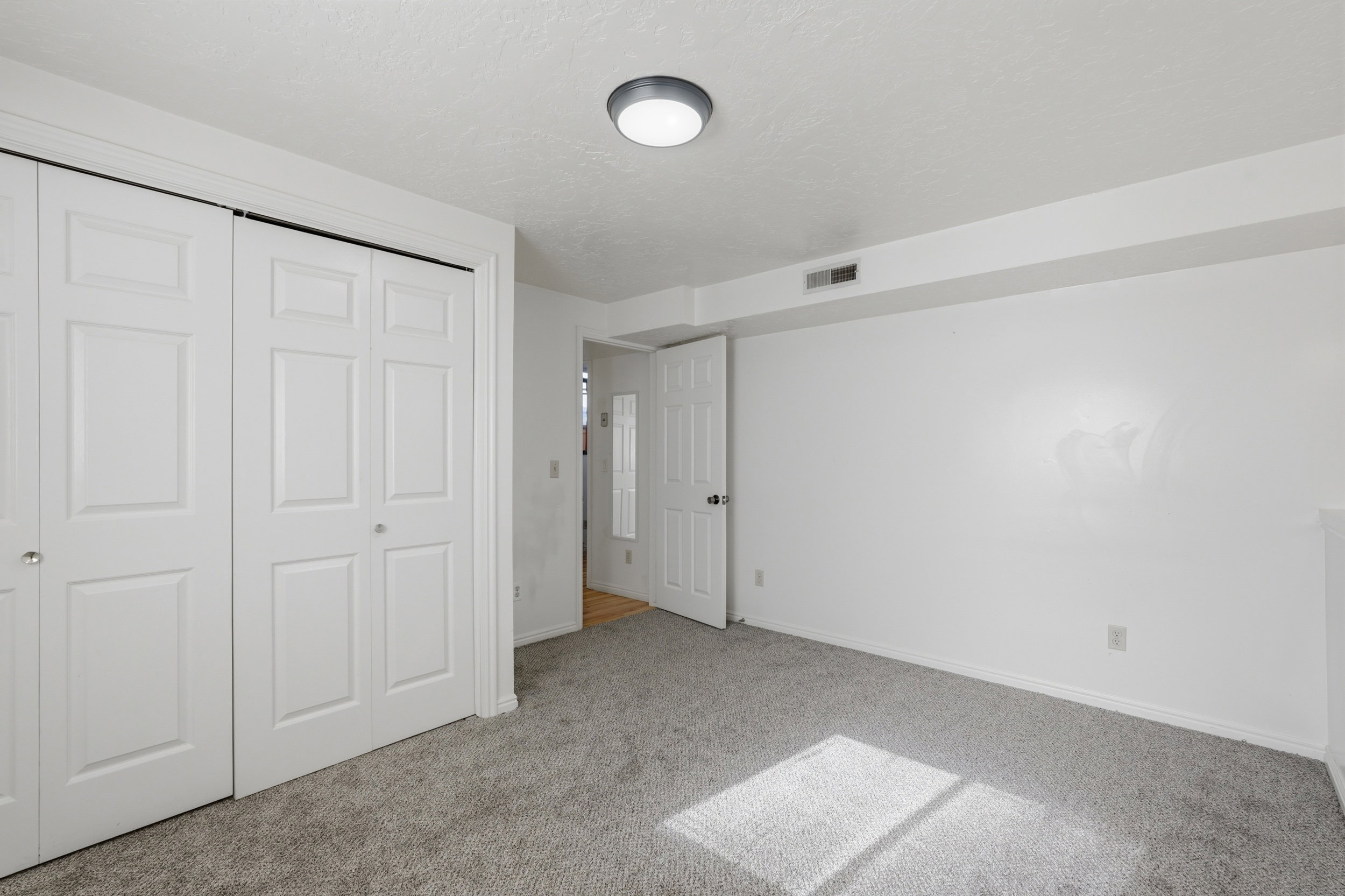 Unfurnished bedroom with a closet, light colored carpet, and a textured ceiling