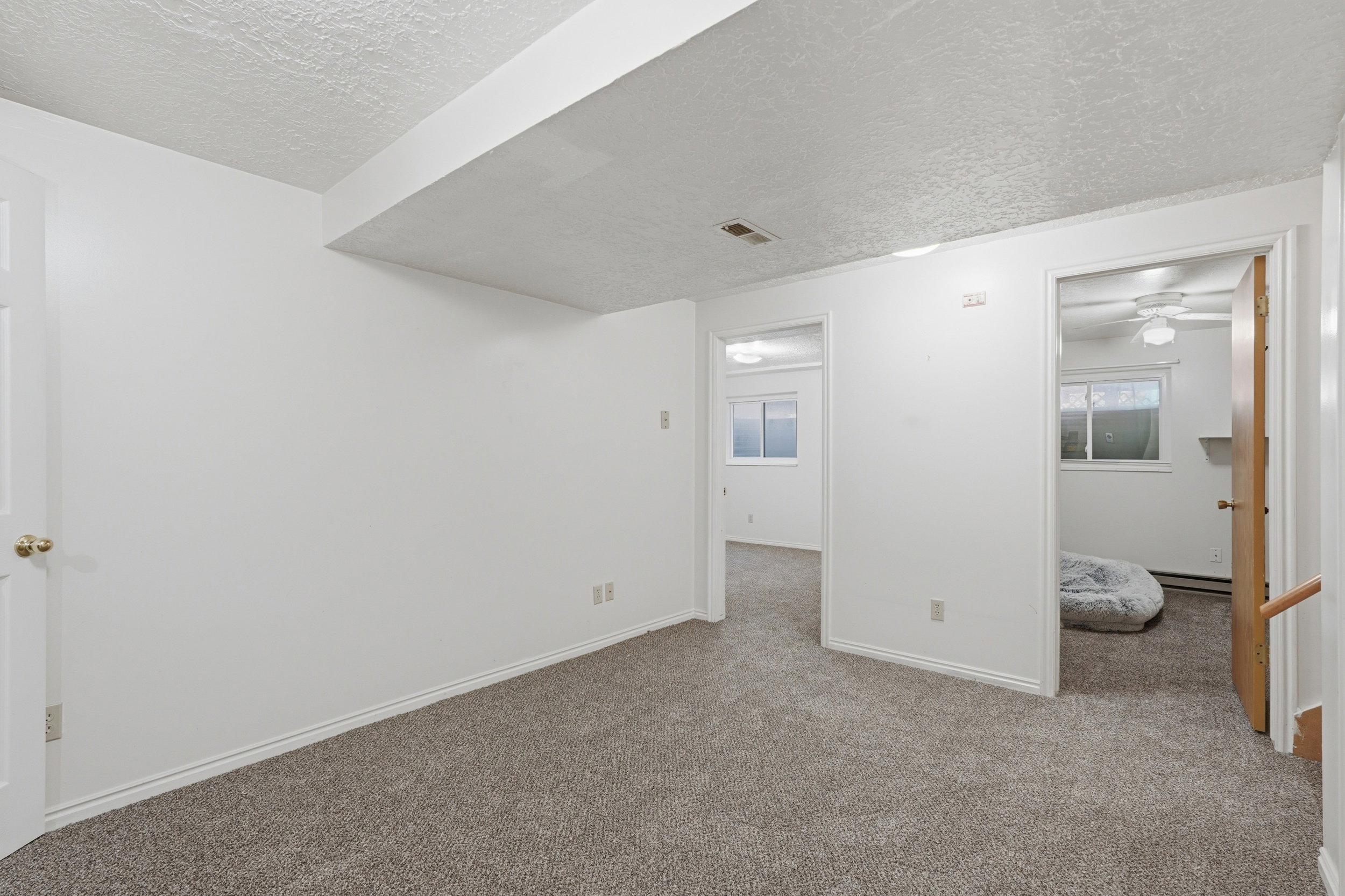 Carpeted spare room featuring a textured ceiling and ceiling fan