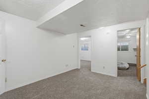 Carpeted spare room featuring a textured ceiling and ceiling fan