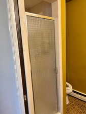 Full bath with a baseboard radiator and a stall shower